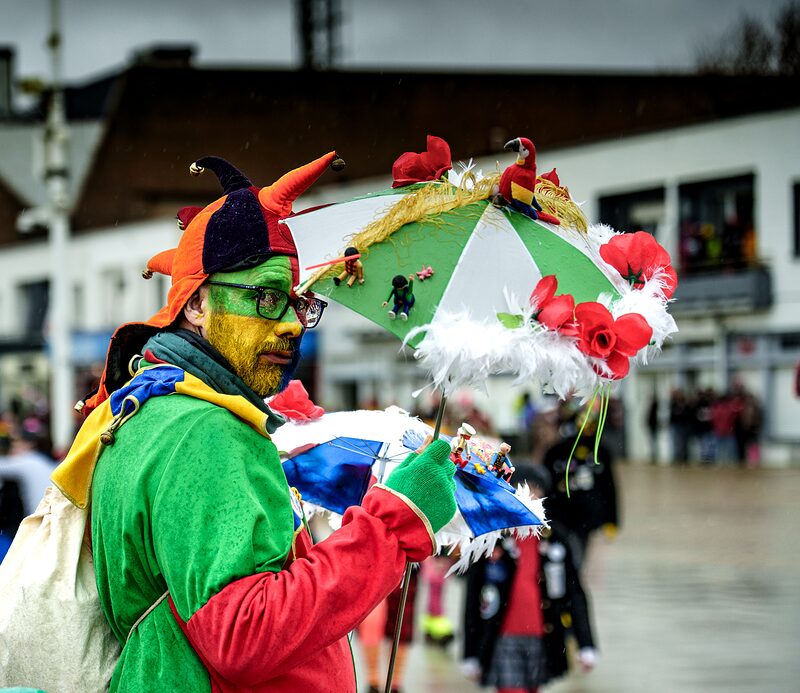 Carnavaleux en costumes et couvre-chef vert défilant dans les rues de Dunkerque 2026.