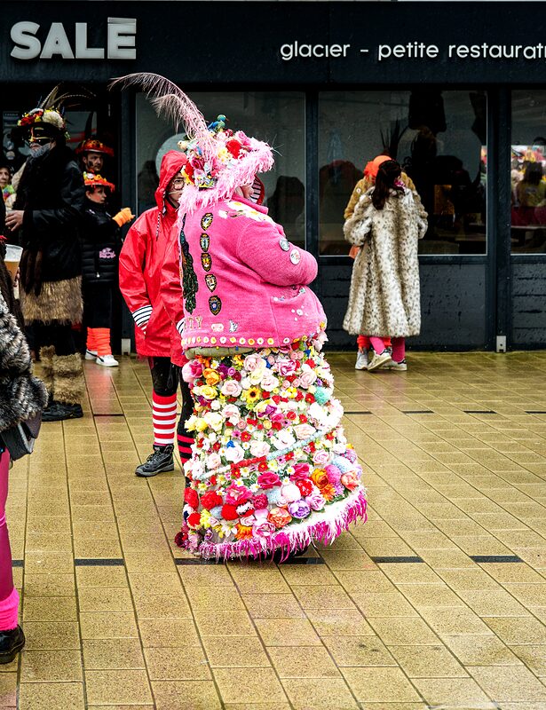 Bande carnavalesque avec bannières et instruments de musique avançant dans le défilé.