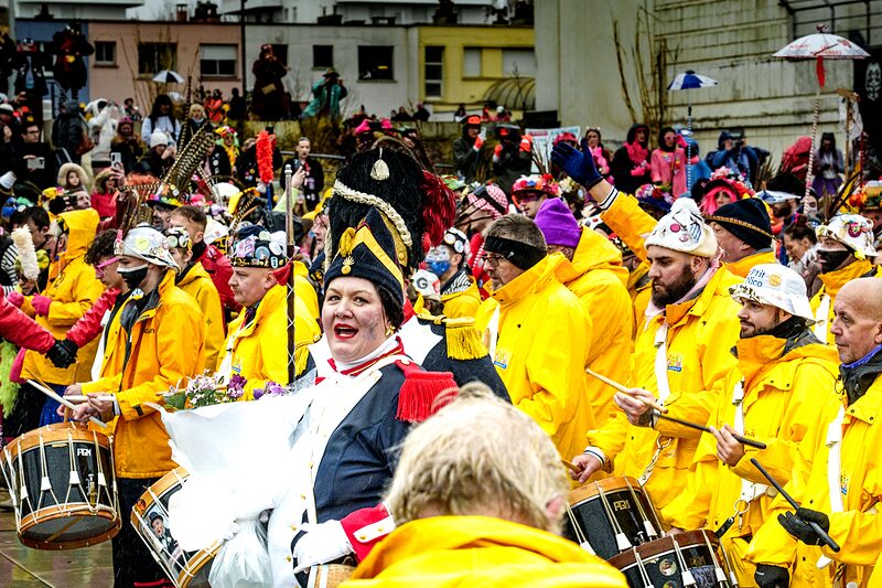 Carnavaleux illuminés par les lumières de la ville pendant le défilé nocturne du Carnaval de Dunkerque.