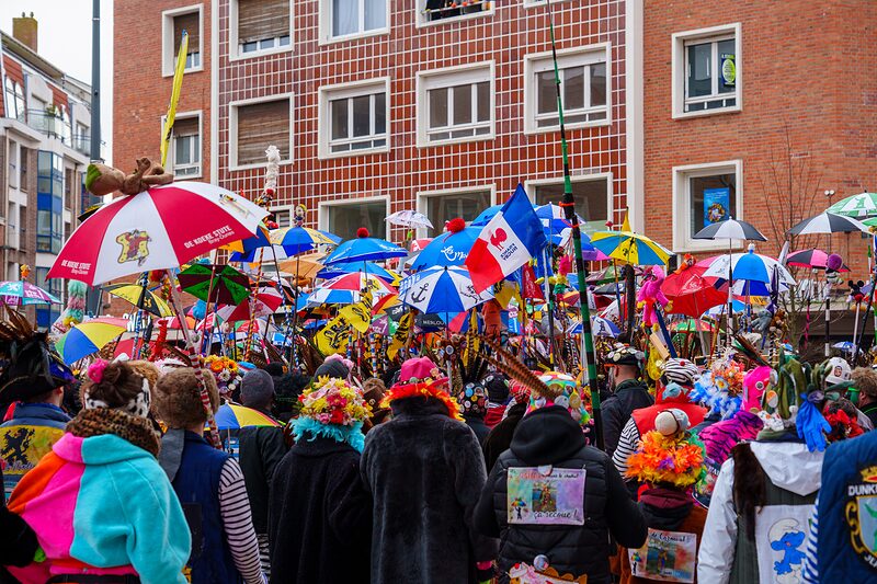 Danseurs traditionnels en clet'ches colorés défilant dans les rues de Dunkerque.