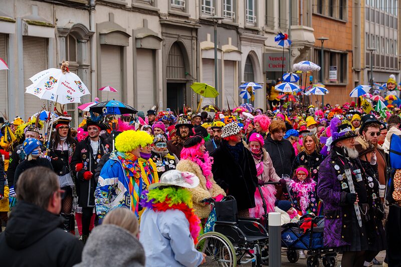 Carnavaleux illuminés par les lumières de la ville pendant le défilé nocturne du Carnaval de Dunkerque.