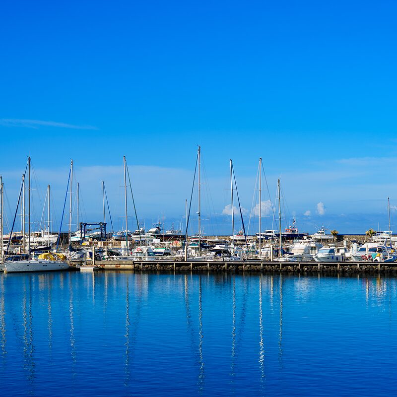 SPetit port de pêche de Terres-Sainte par beau temps avec le reflet des mâts dans l'onde bleue, Réunion, 2025.