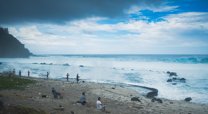Sur la plage de Grand Anse des pêcheurs en action face à un océan agité, côte sud-ouest de la Réunion, 2025.