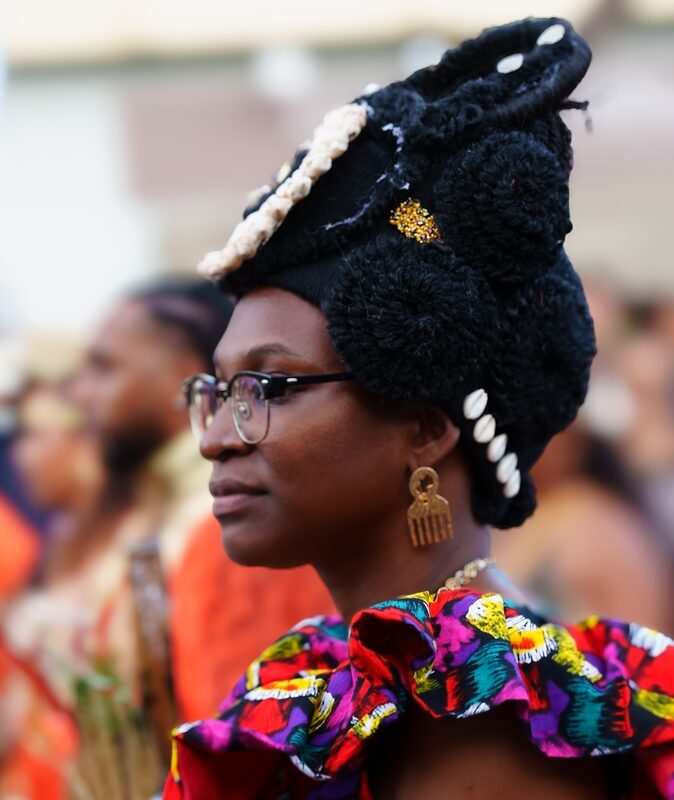 Jeune réunionnaise avec une robe colorée et une coiffe haute, Réunion 2025.